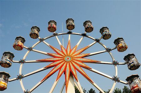 Bottom up view of Ferris wheel against blue sky in a park Stock Photo - Budget Royalty-Free & Subscription, Code: 400-06203152