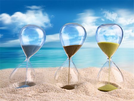 sand clock - Three hourglass in the sand with blue sky Photographie de stock - Aubaine LD & Abonnement, Code: 400-06203367
