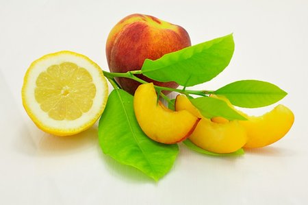 simsearch:400-05664137,k - Fresh peach slices, peach, lemon and green leaves Stock Photo - Budget Royalty-Free & Subscription, Code: 400-06203595