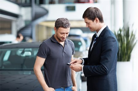 Young man with a salesman in a motor show Stock Photo - Budget Royalty-Free & Subscription, Code: 400-06366591