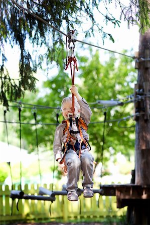 adorable cheerful little boy ziplining in the forest Stock Photo - Budget Royalty-Free & Subscription, Code: 400-06367319