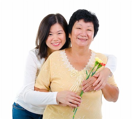 Daughter giving carnation flowers to her mother over white background Photographie de stock - Aubaine LD & Abonnement, Code: 400-06363732