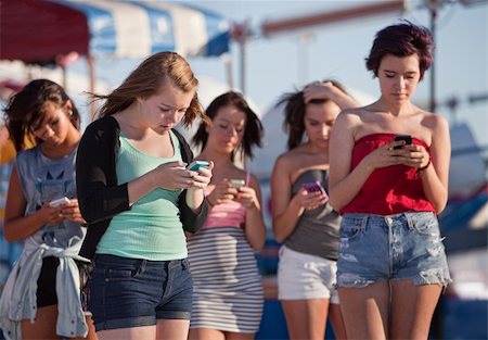 simsearch:400-04099373,k - Young woman at amusement park using their phones Stock Photo - Budget Royalty-Free & Subscription, Code: 400-06394245