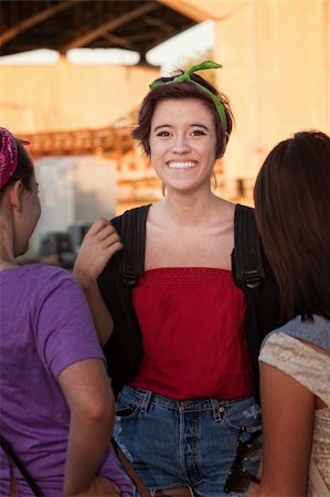 simsearch:400-04099373,k - Flattered teenage girl talking with friends outdoors Stock Photo - Budget Royalty-Free & Subscription, Code: 400-06394259
