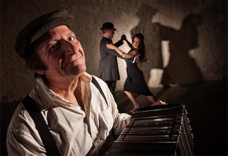 Smiling accordion player performing with dancers in the background Foto de stock - Super Valor sin royalties y Suscripción, Código: 400-06395178