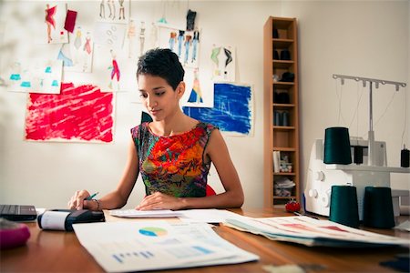 diego_cervo (artist) - Money and financial planning, young hispanic self-employed woman checking bills and doing budget with calculator, computer and papers in fashion design studio Stock Photo - Budget Royalty-Free & Subscription, Code: 400-06395929