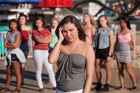 peer pressure - Depressed young woman away from friends at amusement park Stock Photo - Budget Royalty-Free & Subscription, Code: 400-06391965