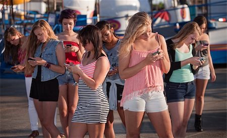 simsearch:400-04099373,k - Eight teenage girls distracted with their phones at carnival Stock Photo - Budget Royalty-Free & Subscription, Code: 400-06391981