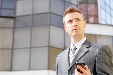 simsearch:859-06710917,k - businessman holds the phone on the building background Stock Photo - Budget Royalty-Free & Subscription, Code: 400-06393704