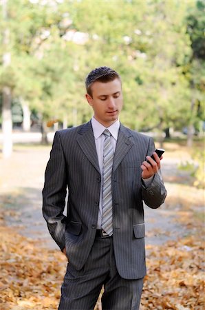 simsearch:859-06710917,k - businessman looks on the phone  in the autumn park Stock Photo - Budget Royalty-Free & Subscription, Code: 400-06393710