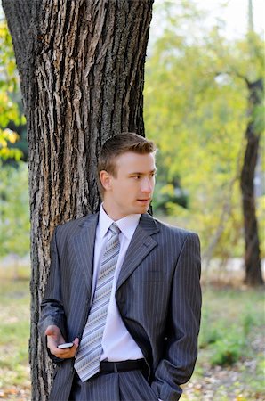 simsearch:859-06710917,k - businessman looks on the phone  in the autumn park Stock Photo - Budget Royalty-Free & Subscription, Code: 400-06393727