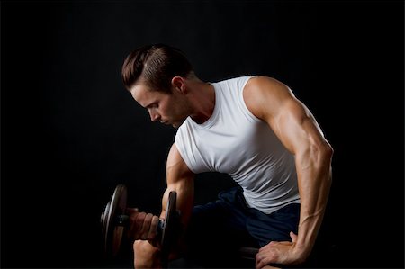 Attractive male doing dumbbell lifts and flexing arm Stock Photo - Budget Royalty-Free & Subscription, Code: 400-06416609