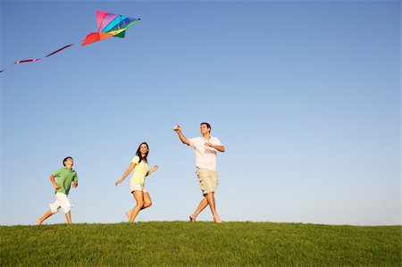 flying kite kids running - Young family, parents with child, playing in a field Stock Photo - Budget Royalty-Free & Subscription, Code: 400-06419404