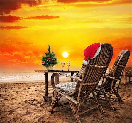 Christmas tree, Two glasses of champagne and Christmas hat on the chair on the beach with view to the ocean  and orange sunset sky in Goa, India Stock Photo - Budget Royalty-Free & Subscription, Code: 400-06481948