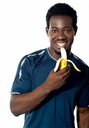 simsearch:400-06482604,k - Young fit guy eating banana. Posing in front of camera Stock Photo - Budget Royalty-Free & Subscription, Code: 400-06482606