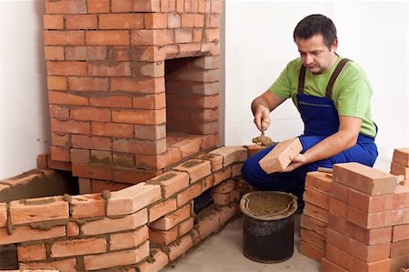 Construction of a masonry heater - worker building the firebox and the flue area Stock Photo - Budget Royalty-Free & Subscription, Code: 400-06515174