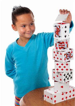 playing card houses - A young girl concentrates whilst laying the final card to complete her playing card tower. Stock Photo - Budget Royalty-Free & Subscription, Code: 400-06519199