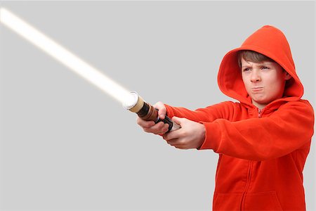 eye laser beam - Young boy in hoodie holding a lightsaber Photographie de stock - Aubaine LD & Abonnement, Code: 400-06528750