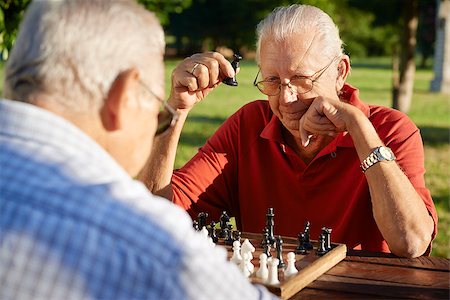 simsearch:400-06142278,k - Active retired people, old friends and free time, two senior men having fun and playing chess at park. Head and shoulders Stock Photo - Budget Royalty-Free & Subscription, Code: 400-06531000