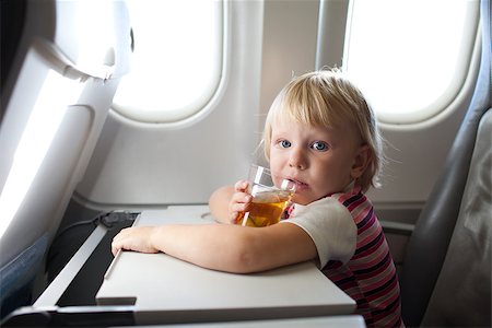 child with juice in airplane Stock Photo - Budget Royalty-Free & Subscription, Code: 400-06557073