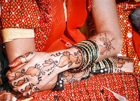 Hands of a young Indian woman adorned with traditional bangles and mehndi. Mehandi, also known as henna is a temporary form of skin decoration in India. Stock Photo - Budget Royalty-Free & Subscription, Code: 400-06558560