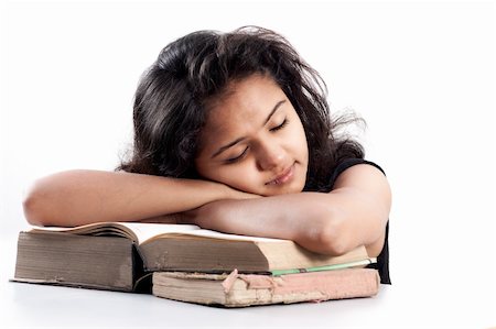 Tired Young indian girl leaned over pile of books, isolated on white Stock Photo - Budget Royalty-Free & Subscription, Code: 400-06553914