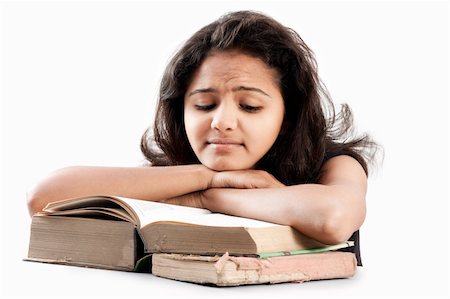 Tired Young indian girl leaned over pile of books, isolated on white Stock Photo - Budget Royalty-Free & Subscription, Code: 400-06553913