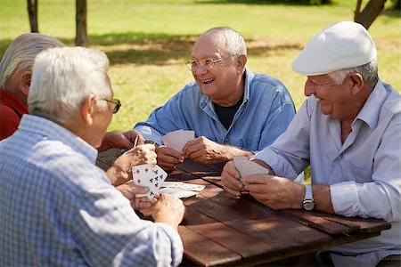 simsearch:400-06142278,k - Active retirement, old people and seniors free time, group of four elderly men having fun and playing cards game at park. Waist up Stock Photo - Budget Royalty-Free & Subscription, Code: 400-06566118