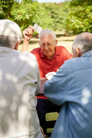 simsearch:400-06142278,k - Active retirement, old people and seniors free time, group of three elderly men having fun and playing cards game at park. Waist up Stock Photo - Budget Royalty-Free & Subscription, Code: 400-06566119
