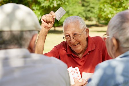 simsearch:400-06142278,k - Active retirement, old people and seniors free time, group of three elderly men having fun and playing cards game at park Stock Photo - Budget Royalty-Free & Subscription, Code: 400-06569782