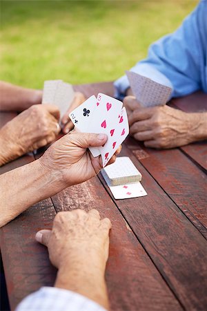 simsearch:400-06142278,k - Active retirement, old people and seniors free time, group of three elderly men having fun and playing cards game at park Stock Photo - Budget Royalty-Free & Subscription, Code: 400-06569783