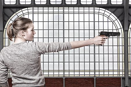 Young girl with a handgun Stock Photo - Budget Royalty-Free & Subscription, Code: 400-06561571