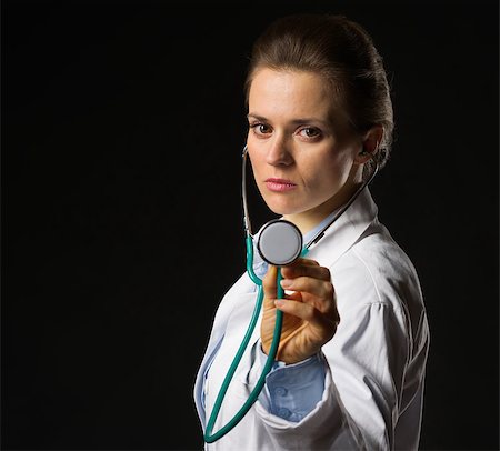 Confident medical doctor woman using stethoscope isolated on black Stock Photo - Budget Royalty-Free & Subscription, Code: 400-06562763