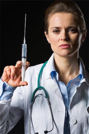 Medical doctor woman holding syringe isolated on black Stock Photo - Budget Royalty-Free & Subscription, Code: 400-06562779