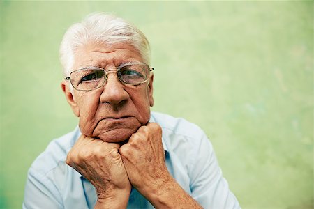 simsearch:400-06142278,k - people and emotions, portrait of depressed senior hispanic man with glasses looking at camera, leaning with hands on chin. Copy space Stock Photo - Budget Royalty-Free & Subscription, Code: 400-06570246