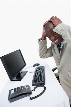 simsearch:400-05748170,k - Side view of a furious businessman using a monitor against white background Stock Photo - Budget Royalty-Free & Subscription, Code: 400-06627036