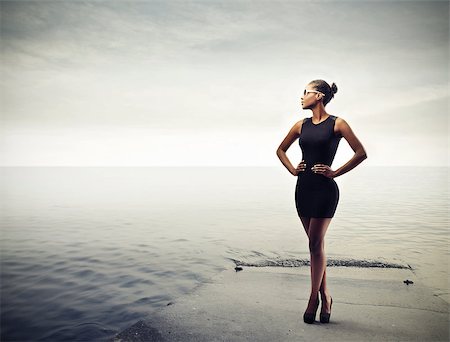 simsearch:400-06628918,k - Elegant black girl with a black dress standing on a pier Photographie de stock - Aubaine LD & Abonnement, Code: 400-06628919