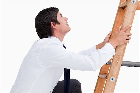 entrepreneur human sale - Side view of young tradesman climbing on a ladder against a white background Stock Photo - Budget Royalty-Free & Subscription, Code: 400-06634225