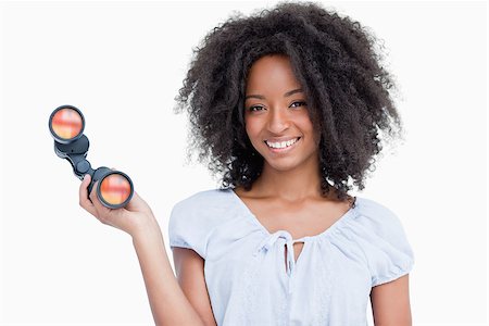 Young woman with curly hairstyle holding binoculars against a white background Stock Photo - Budget Royalty-Free & Subscription, Code: 400-06635125