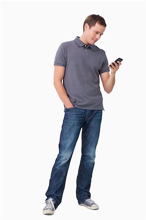 simsearch:400-06632132,k - Young man typing text message on his cellphone against a white background Stock Photo - Budget Royalty-Free & Subscription, Code: 400-06632130