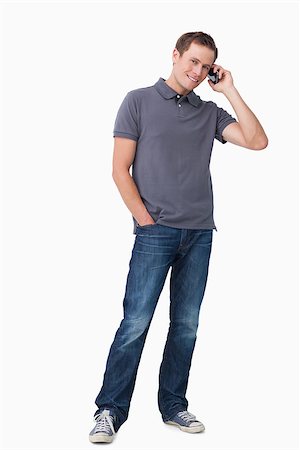 simsearch:400-06632132,k - Smiling young man on his cellphone against a white background Stock Photo - Budget Royalty-Free & Subscription, Code: 400-06632131