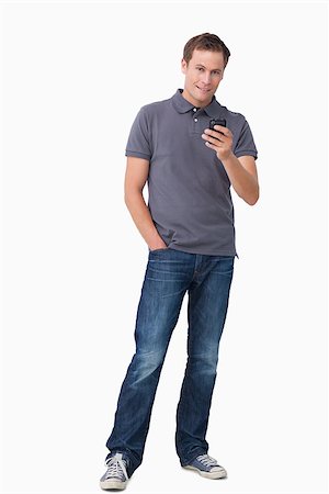 simsearch:400-06632132,k - Young man holding his cellphone against a white background Stock Photo - Budget Royalty-Free & Subscription, Code: 400-06632132