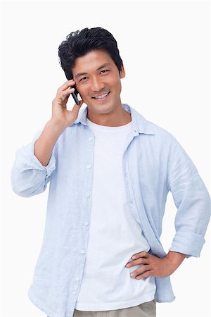 simsearch:400-06632132,k - Smiling male on mobile phone against a white background Stock Photo - Budget Royalty-Free & Subscription, Code: 400-06632284