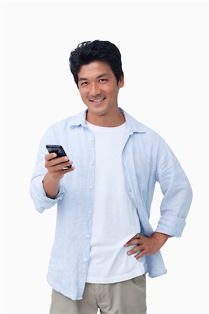 simsearch:400-06632132,k - Smiling male with his cellphone against a white background Stock Photo - Budget Royalty-Free & Subscription, Code: 400-06632288