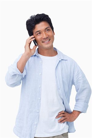 simsearch:400-06632132,k - Smiling male on his mobile phone against a white background Stock Photo - Budget Royalty-Free & Subscription, Code: 400-06632283