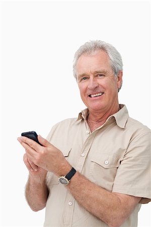 simsearch:400-06632132,k - Smiling mature male typing a text message against a white background Stock Photo - Budget Royalty-Free & Subscription, Code: 400-06632309
