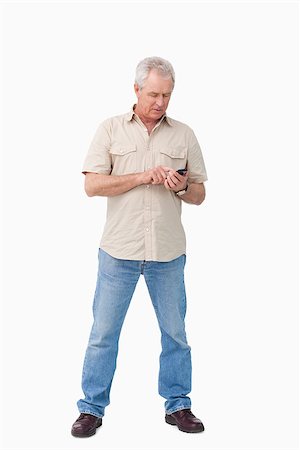simsearch:400-06632132,k - Mature man writing text message against a white background Stock Photo - Budget Royalty-Free & Subscription, Code: 400-06632300