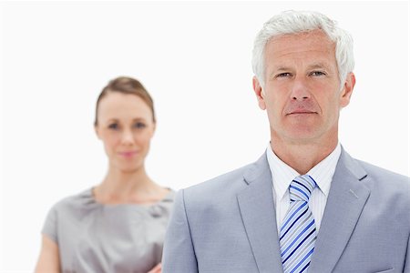 Close-up of a serious white hair businessman with a woman him behind against white background Stock Photo - Budget Royalty-Free & Subscription, Code: 400-06632559