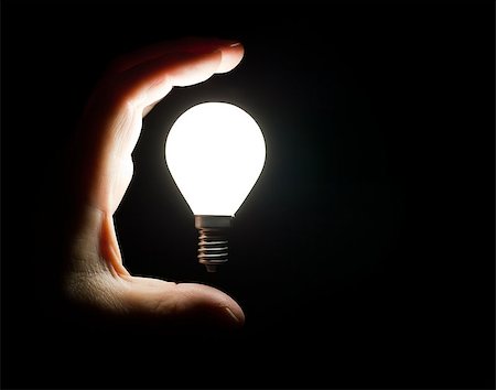 Hand grabbing floating light bulb on black background Stock Photo - Budget Royalty-Free & Subscription, Code: 400-06633872