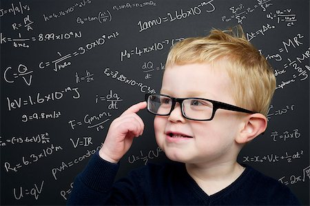 Smart young boy wearing a navy blue jumper and glasses stood infront of a blackboard with scientific formulas and equations written in chalk Stock Photo - Budget Royalty-Free & Subscription, Code: 400-06643638